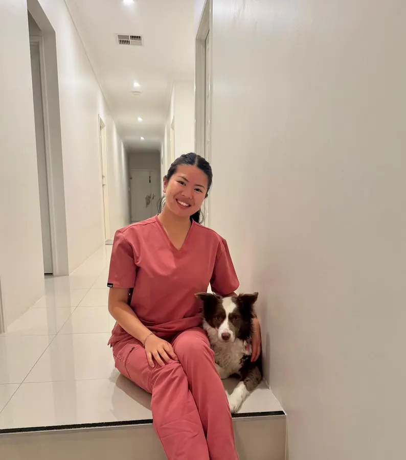 A therapist sitting quietly beside a border collie between appointments